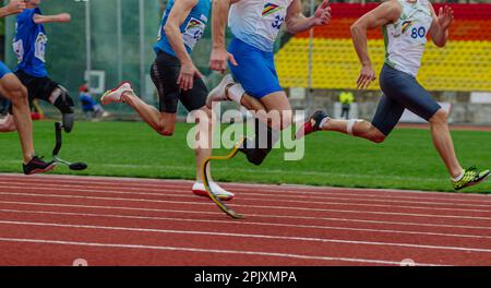 gruppo di corridori maschi con atleta disabile in corsa sprint in gara di atletica para, giochi di sport estivi Foto Stock