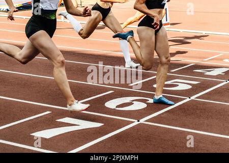 il gruppo femminile di atleta attraversa la linea di arrivo dello stadio di gara sprint, i campionati estivi di atletica Foto Stock