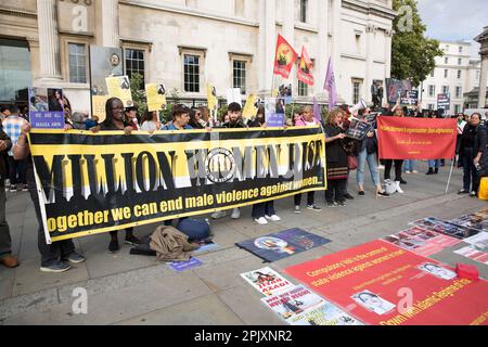 I partecipanti hanno una bandiera che chiede la fine della violenza maschile contro le donne a Londra, mentre le persone si riuniscono a sostegno della libertà delle donne in Iran. Foto Stock