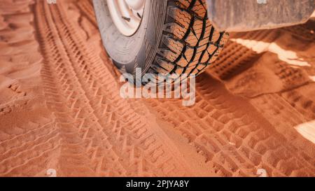 4wd pneumatico del veicolo sporco da polvere - traccia stampata visibile in sabbia rossa, dettaglio primo piano Foto Stock