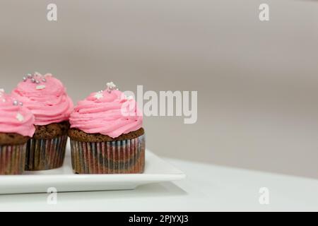 Tortini per le vacanze con crema rosa e ripieno di lamponi. Primo piano Foto Stock