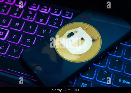 In questa foto, il logo Dogecoin visualizzato sullo schermo di un telefono cellulare. Foto Stock