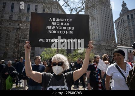 New York, USA 4 aprile 2023 il protester anti-Trump alleva il segno che legge 'Un mazzo di regolari newyorkesi lo ha incriminato - noi stnd con loro' fuori dal tribunale dove gli ex Stati Uniti Il presidente Donald Trump ha dichiarato di non essere colpevole di 34 conti di falsificazione dei record aziendali Foto Stock