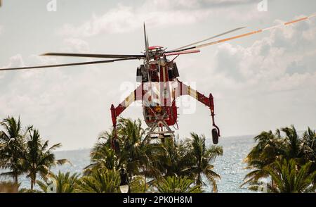 Hallandale Beach, Miami, Florida - 4 aprile 2023: Elicottero che solleva l'enorme Air-Condition Roof Top Centrale unità al tetto della cima del alto edificio Foto Stock