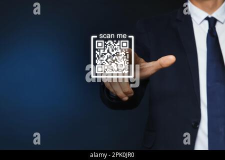 Uomo che indica l'illustrazione del codice QR su sfondo blu scuro, primo piano Foto Stock