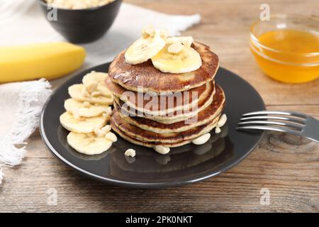 Piatto di frittelle di banana servito su tavolo di legno, guardaroba Foto Stock