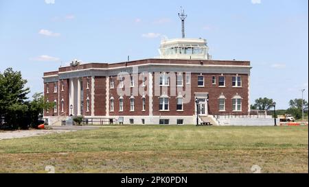 Floyd Bennett Field, edificio Art Deco dell'ex terminal principale e torre di controllo, vista laterale sul campo aereo coperto di erba, New York, NY, USA Foto Stock