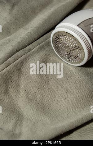 Rasoio anti-pilling. Dispositivo per la rasatura di indumenti in pellet. Rasoio in tessuto anti-peluche. Pulitore elettrico portatile pillola defuzzer pelucchi da acrilico o lana maglione. Sostenibilità stile di vita, riducendo il riciclaggio dei rifiuti di abbigliamento Foto Stock
