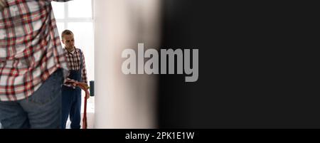 Felice giovane coppia che fa la riparazione nella loro nuova casa. Tempo in famiglia insieme. Giovane uomo e donna a dipingere un muro con un rullo. Il colore della vernice è grigio. Camera Foto Stock