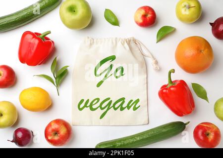 Sacchetto eco di cotone con frase Go Vegan, frutta e verdura su sfondo bianco, piatto Foto Stock