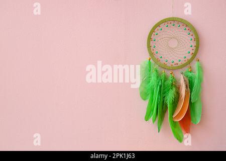 Dream catcher appeso a una parete rosa Foto Stock