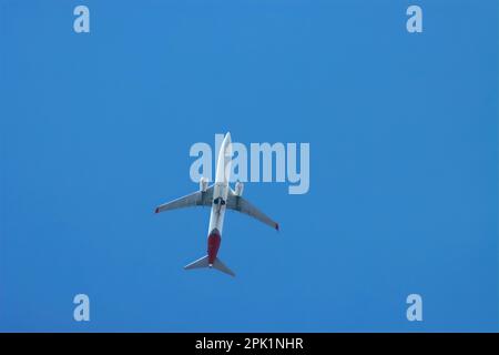Grande jumbo jet in volo in un cielo blu, volando sopra. Foto Stock
