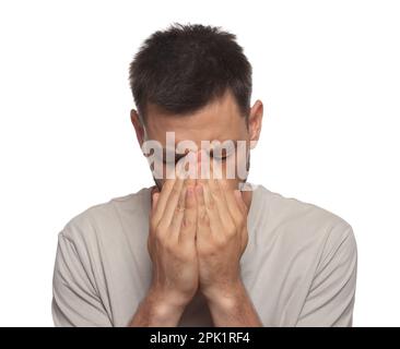 Uomo che soffre di affaticamento degli occhi su sfondo bianco Foto Stock