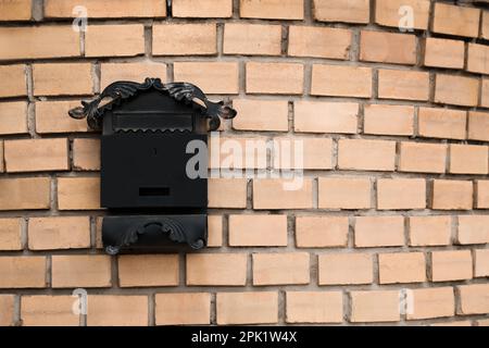 Casella per lettere vintage su parete in mattoni beige, spazio per il testo Foto Stock