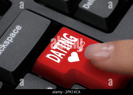 Donna che preme il tasto con la parola Dating sulla tastiera del computer, primo piano Foto Stock