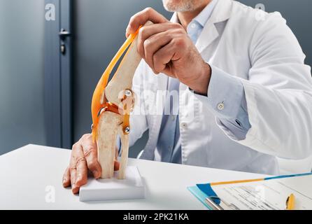 Trattamento per lesioni al ginocchio. Modello anatomico dell'articolazione del ginocchio umano sul tavolo del medico nel centro ortopedico Foto Stock