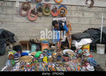 Arusha, Tanzania - 17th ottobre 2022: Una donna che vende prodotti a perline colorate nel mercato di Arusha, Tanzania. Foto Stock