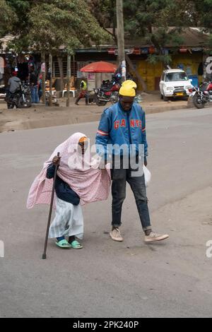 Arusha, Tanzania - 17th ottobre 2022: Un uomo che sostiene una donna anziana nella strada principale di Arusha, Tanzania. Foto Stock