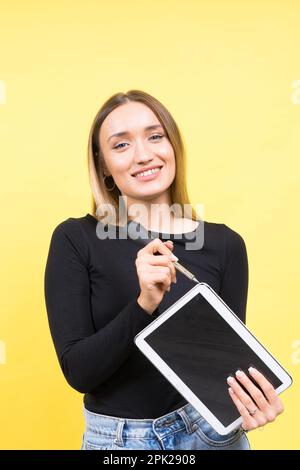 Centro servizi. Riparazione del notebook. Il cacciavite femmina svita i bulloni del computer portatile su sfondo giallo Foto Stock