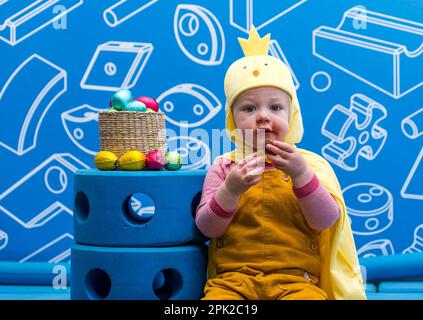 City Art Centre, Edimburgo, Scozia, Regno Unito, 05 aprile 2023. Edinburgh Science Festival: I bambini si preparano per Pasqua rotolando le colorate uova di Pasqua giù per uno scivolo costruito da blocchi di costruzione dall'installazione Imagination Playground. Il City Art Centre dispone di cinque piani di laboratori scientifici pratici e attività ed è il principale luogo di ritrovo per famiglie del Festival, che offre divertimento educativo per tutta la giornata per i bambini tra i 3 e i 12 anni. Foto: James di 18 mesi gode di un uovo di Pasqua al cioccolato. Credit: Sally Anderson/Alamy Live News Foto Stock