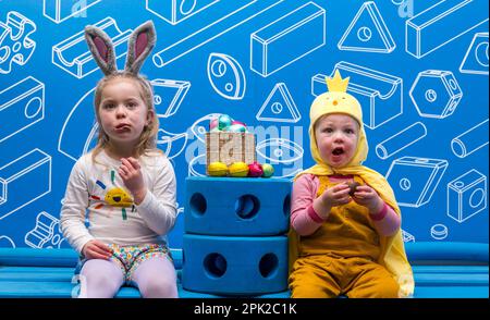 City Art Centre, Edimburgo, Scozia, Regno Unito, 05 aprile 2023. Edinburgh Science Festival: I bambini si preparano per Pasqua rotolando le colorate uova di Pasqua giù per uno scivolo costruito da blocchi di costruzione dall'installazione Imagination Playground. Il City Art Centre dispone di cinque piani di laboratori scientifici pratici e attività ed è il principale luogo di ritrovo per famiglie del Festival, che offre divertimento educativo per tutta la giornata per i bambini tra i 3 e i 12 anni. Nella foto: Dorothy, di 4 anni e James, di 18 mesi, godono di uova di Pasqua al cioccolato. Credit: Sally Anderson/Alamy Live News Foto Stock