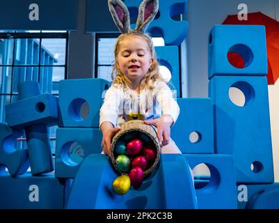 City Art Centre, Edimburgo, Scozia, Regno Unito, 05 aprile 2023. Edinburgh Science Festival: I bambini si preparano per Pasqua rotolando le colorate uova di Pasqua giù per uno scivolo costruito da blocchi di costruzione dall'installazione Imagination Playground. Il City Art Centre dispone di cinque piani di laboratori scientifici pratici e attività ed è il principale luogo di ritrovo per famiglie del Festival, che offre divertimento educativo per tutta la giornata per i bambini tra i 3 e i 12 anni. Nella foto: Dorothy, 4 anni di esperienza con uova di Pasqua e uno scivolo. Credit: Sally Anderson/Alamy Live News Foto Stock