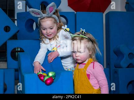 City Art Centre, Edimburgo, Scozia, Regno Unito, 05 aprile 2023. Edinburgh Science Festival: I bambini si preparano per Pasqua rotolando le colorate uova di Pasqua giù per uno scivolo costruito da blocchi di costruzione dall'installazione Imagination Playground. Il City Art Centre dispone di cinque piani di laboratori scientifici pratici e attività ed è il principale luogo di ritrovo per famiglie del Festival, che offre divertimento educativo per tutta la giornata per i bambini tra i 3 e i 12 anni. Nella foto: Dorothy, 4 anni di esperienza con le uova di Pasqua e uno scivolo guardato da James, 18 mesi. Credit: Sally Anderson/Alamy Live News Foto Stock