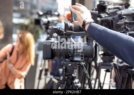 Utilizzo dello smartphone durante un evento multimediale. Concetto di giornalismo sociale o cittadino. Foto Stock