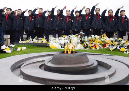 NANJING, CINA - 5 APRILE 2023 - gli studenti delle scuole elementari salutano il monumento ai martiri di Yuhuatai a Nanjing, nella Provincia di Jiangsu della Cina Orientale, il 5 aprile 2 Foto Stock