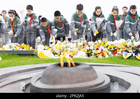 NANJING, CINA - 5 APRILE 2023 - gli studenti della scuola elementare presentano fiori al monumento ai martiri Yuhuatai a Nanjing, nella provincia di Jiangsu, Nella Cina orientale Foto Stock