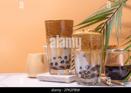 Caffè Boba dalgona. Drink mattutino asiatico alla moda con caffè istantaneo e palline di perle di tapioca, bicchiere da cocktail thai estivo in sole Foto Stock