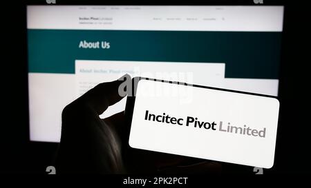 Persona in possesso di smartphone con il logo della società australiana Incitec pivot Ltd. Sullo schermo di fronte al sito web. Messa a fuoco sul display del telefono. Foto Stock