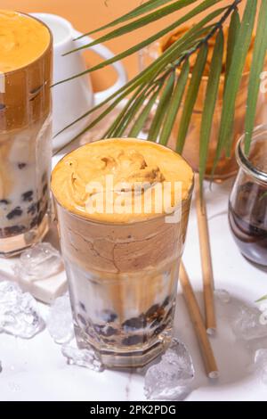 Caffè Boba dalgona. Drink mattutino asiatico alla moda con caffè istantaneo e palline di perle di tapioca, bicchiere da cocktail thai estivo in sole Foto Stock