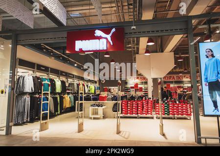 Ingresso al negozio Puma Outlet con logo in un centro commerciale. Una multinazionale tedesca che progetta e produce calzature, abbigliamento e accessori. Vilnius, Lituania - 8 marzo 2023. Foto Stock