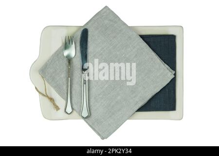 Tavolo da cucina con un tovagliolo di lino e un coltello con una forchetta isolata su sfondo bianco. Vista dall'alto. Foto Stock