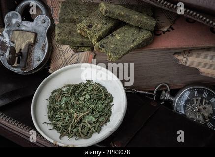 Bangkok, Thailandia - Mar 17, 2023 : spuntini di Cannabis fatti in casa sul notebook della Vecchia Musica con le foglie di Cannabis tagliate nel piccolo piatto di ferro b Foto Stock