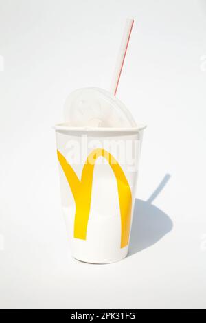 Ho Chi Minh City, Vietnam - 2 marzo 2023: Catena fast food McDonalds tazza di carta stropicciata con una paglia e un cappuccio isolato su bianco. Tazza usata con un tuorlo Foto Stock