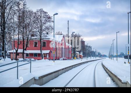 Krustpils, Lettonia - 9 dicembre 2022: Vista della stazione ferroviaria di Krustpils in una giornata invernale. Piattaforma ferroviaria e ferrovia. Foto Stock