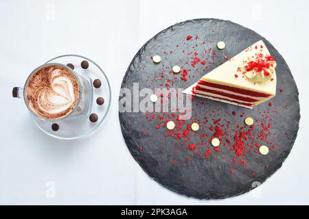 Cheesecake alle fragole con una bevanda calda su sfondo bianco Foto Stock