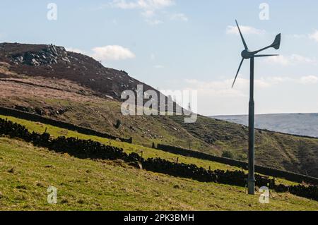 Intorno al Regno Unito - Un mulino a vento domestico regolato contro gli affioramenti della pietra gritstone su Bridestones Moor, Todmorden Foto Stock