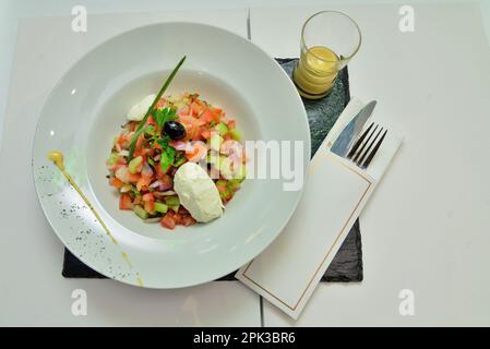 Un'insalata marocchina di pomodoro, cetriolo, cipolla e coriandolo (coriandolo) lascia inzuppare nell'olio d'oliva e nell'aceto e termina con succo di limone Foto Stock