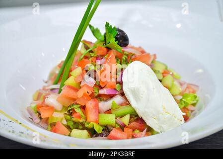 Un'insalata marocchina di pomodoro, cetriolo, cipolla e coriandolo (coriandolo) lascia inzuppare nell'olio d'oliva e nell'aceto e termina con succo di limone Foto Stock