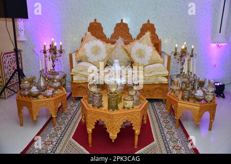 Un matrimonio in stile tradizionale marocchino allestito elegantemente con un grande divano per la coppia di nozze da sedere e ricevere benedizioni dagli ospiti, circondato Foto Stock