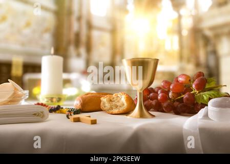 Rappresentazione dell'ultima cena con cibi sacri su un tavolo con una tovaglia bianca in una chiesa. Vista frontale. Foto Stock