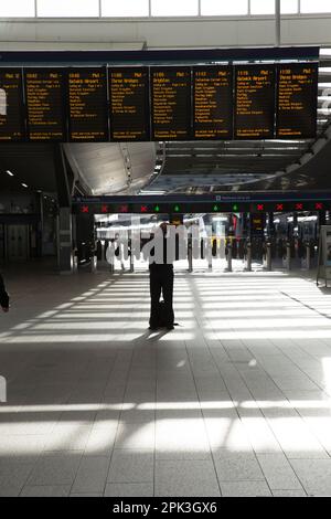 Un passeggero viene inzagliato contro un atrio scintillante alla stazione ferroviaria di London Bridge mentre i lavoratori ferroviari sono in sciopero. Foto Stock