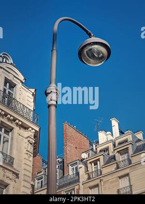 Lampada da strada in stile retrò in un vecchio quartiere di Parigi con vista sullo sfondo blu del cielo Foto Stock
