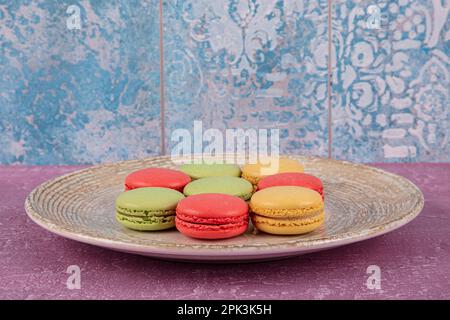 Torte di macaron colorate. Piccoli muffin francesi. Amaretti francesi dolci e colorati. Macaron colorati su sfondo di marmo grigio. Vista dall'alto. colo pastello Foto Stock