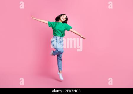 Corpo fotografico a tutta lunghezza di giovani saltando incurante donna volante le ali celebrano le mestruazioni leggerezza isolato su sfondo di colore rosa Foto Stock