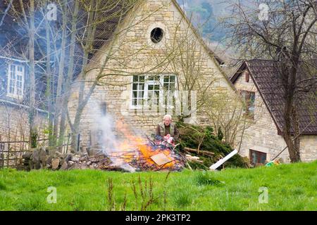 L'uomo fa un falò di legno spazzatura e rifiuti da giardino a Batheaston, Somerset, Regno Unito Foto Stock