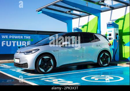 Auto elettrica Regno Unito - ricarica di un'auto elettrica presso un caricabatterie pubblico per auto elettriche in una stazione di ricarica EV MFG EV per il Regno Unito Foto Stock